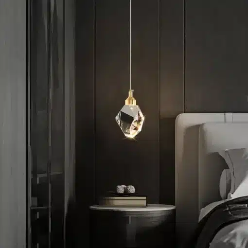 Stiilne luksuslik kristallidega ripplamp, mis ripub kaasaegse öökapi kohal tumedas ja elegantses magamistoas. Lamp peegeldab pehmelt valgust, luues sooja ja kutsuva atmosfääri.