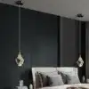 Kaunid luksuslikud kristallidega ripplambid, mis ripuvad elegantselt kahe voodi kohal, valgustades tumedat modernset magamistuba. Lambi kristallid lisavad ruumi luksust ja sära.