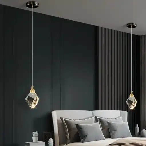Kaunid luksuslikud kristallidega ripplambid, mis ripuvad elegantselt kahe voodi kohal, valgustades tumedat modernset magamistuba. Lambi kristallid lisavad ruumi luksust ja sära.