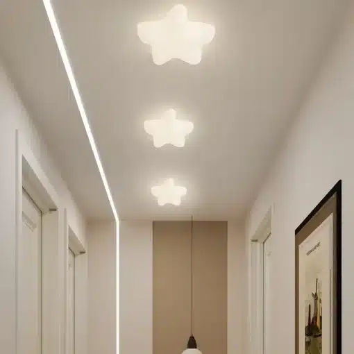 Kolm valget tähtkujuliselt LED sisevalgustit annavad pehme kuma helehallil koridori lael, luues õhulise ja rahustava atmosfääri. Taustal hele sein ja uksed raamitud modernses stiilis.