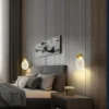 Kaasaegses magamistoas hallide seinte taustal rippuvad kaks energiasäästlikku ja moodsa disainiga rippvalgustit, mis loovad sooja ja hubase valguse. Voodi on kaetud hallide ja valgete patjadega ning öökapil on lilledega vaas.