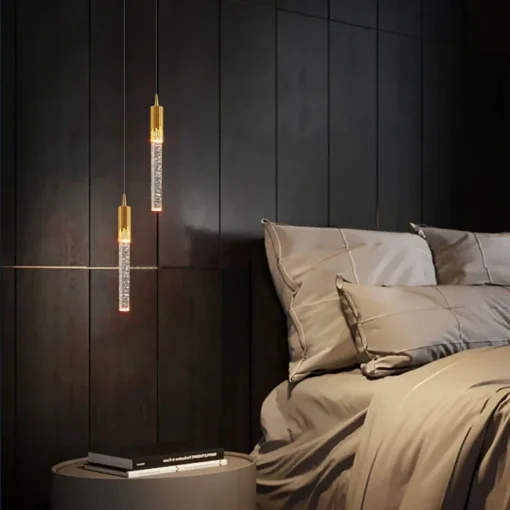 Elegantsed, energiasäästlikud ja moodsad rippvalgustid, millel on kuldsed toonid ja kristallilised detailid, ripuvad modernses magamistoas tumedal puidust seinal voodi kõrval.