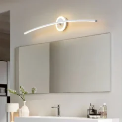 Moodsa disainiga LED seinalamp valgustab elegantset vannituba, paigutatud peegli kohale heledale seinapinnale, pakkudes sooja valgust ja stiilset välimust.