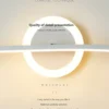 Moodsad disain LED seinalambid valge minimalistliku ringikujulise disainiga, rõhutades detailset käsitööd ja elegantset valgusjaotust helebeežis taustas.