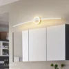 Moodsad disain LED seinalambid valge minimalistliku valgustusega vannitoas, seinakapi kohal. Lambi kaarjas kuju lisab ruumile kaasaegse ja stiilse ilme, valgustades meeldivalt neutraalset seina.