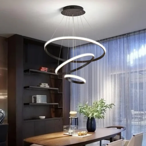 Eksklusiivne LED elutoa rippvalgusti, mis ripub elegantselt söögilaua kohal. Valgusti koosneb kahest järk-järgult kitsenevast mustast rõngast, mis toetavad peent, heledalt helendavat LED-riba. Taustal on luksuslik, kõrge laega tuba koos suurte akendega, kust paistab looduslik valgus.