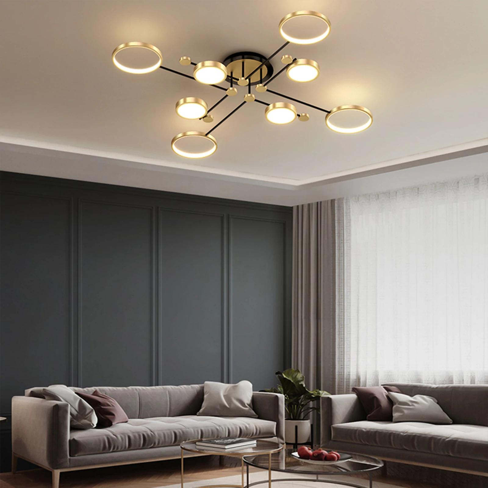 Stiilne šampanja-halli värvi puldiga lühter, mis ripub esinduslikus elutoas elegantse diivani ja neutraalsete kardinate kohal.