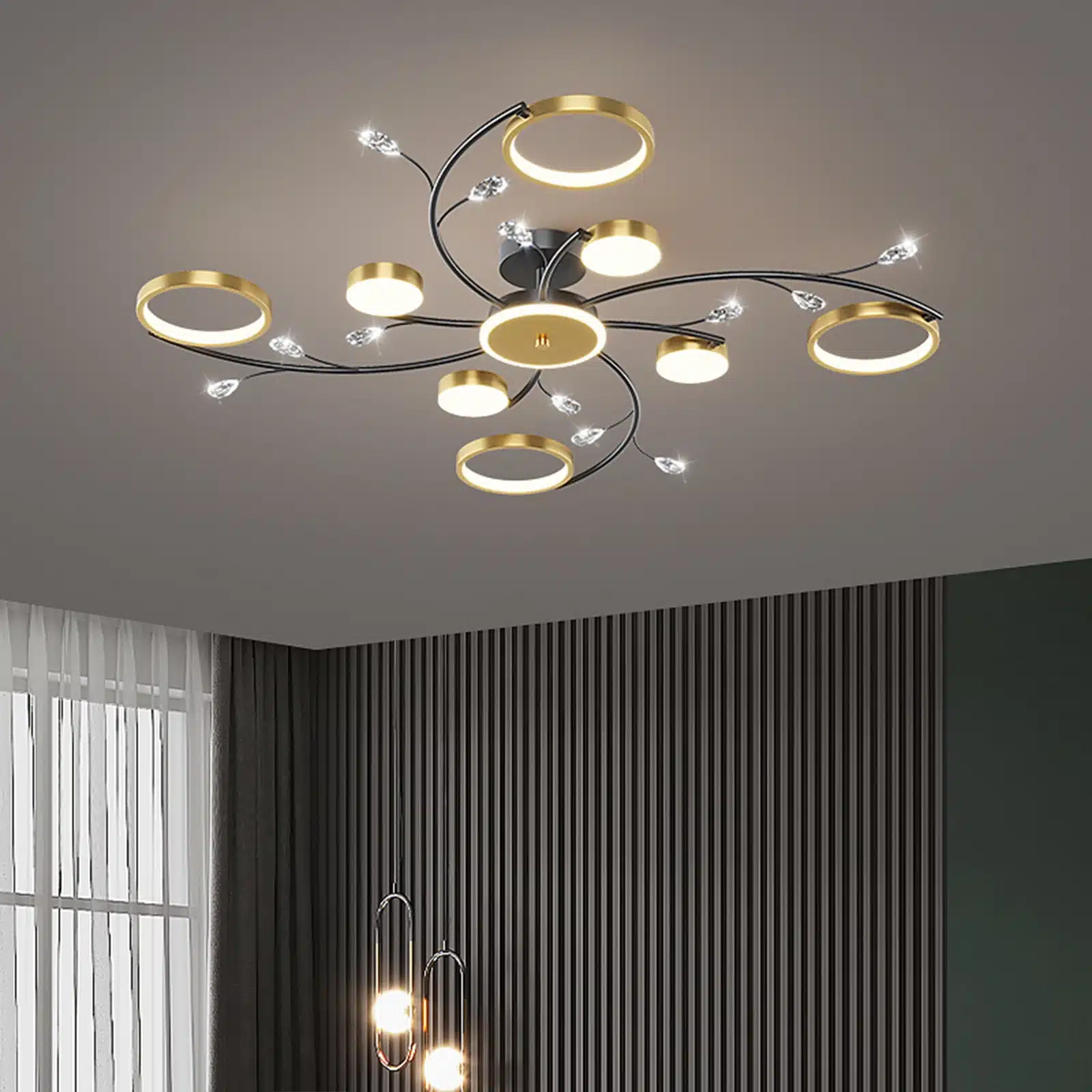 Moodne puldiga laelamp elutuppa või magamistuppa, kuldsete rõngaste ja LED-tuledega, paistab elegantselt hallilt laelt triibulise seinaga taustal.