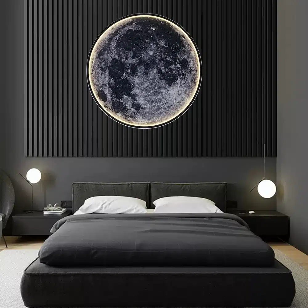 Moodne magamistuba, kus seinal on suur Ilus LED kuuvalgusti, mis imiteerib detailset kuu pinda pehme halli ja musta värvikombinatsiooniga. Tumeda mööbli ja minimalistlike elementidega ruum loob rahuliku atmosfääri.
