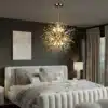 Kristalllaelamp ilutulestiku efektiga | E-pood Tootemaailm Kristalllaelamp ilutulestiku efektiga ripub elegantse magamistoa laes, heledal taustal, koos neutraalsete toonidega voodi ja kardinatega.