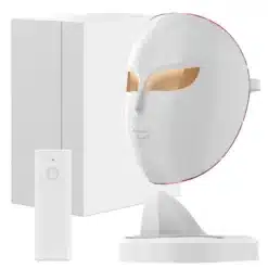 Valge efektiivne valgusteraapia mask näonaha pingutamiseks ja noorendamiseks koos juhtimisseadmega. Maskil on kuldsed silmaavad ja see asub elegantse aluse peal minimalistliku taustaga.