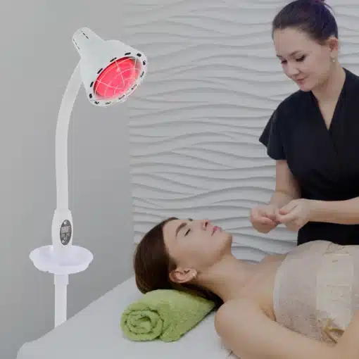 Võimas infrapuna füsioteraapia lamp valu leevendamiseks | E-pood Tootemaailm Massaažilaual lamav naine, kelle pea all on roheline rätik, ning ülal hõljuv võimas infrapuna füsioteraapia lamp valu leevendamiseks, mida juhendab terapeut heledate laineliste seinte taustal.