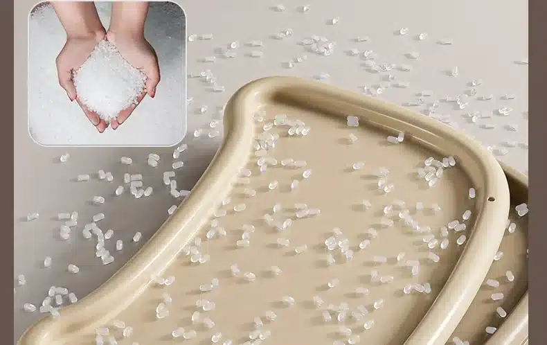 Kerge kokkupandav beebide söögitool toidualusega, millel on laiali puistatud mitmeotstarbeline graanulmaterjal. Taust on neutraalset beeži tooni, tuues esile materjali kvaliteedi.