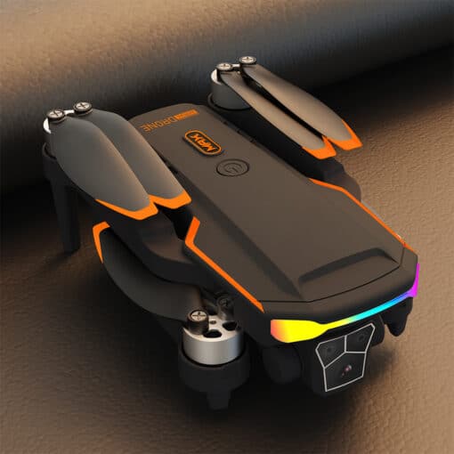 droon F168 süsinikkiud takistuste vältimine | E-pood Tootemaailm Drone F168 Brushless Optical Flow Obstacle Avoidance Aerial Photography Quadcopter, featuring a sleek black and orange design, compactly folded on a textured brown leather surface.