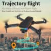 droon F168 süsinikkiud takistuste vältimine | E-pood Tootemaailm Drone F168 harjadeta mootoriga must-oranž optilise voolu ja takistuste vältimise funktsiooniga droon, mis lendab linna kohal. Taustal on päikeseloojanguline taevas ja pilvelõhkujad, drooni all on digitaalne lennurada.