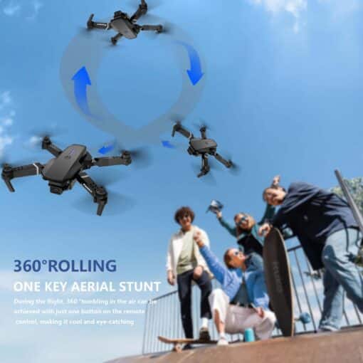 Kahe kaameraga kokkupandav droon algajatele, must/hall | E-pood Tootemaailm E88 Dual Camera Drone performing a 360-degree aerial stunt against a bright blue sky, surrounded by excited people holding skateboards and cameras, showcasing its advanced features and outdoor fun capabilities.