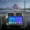 2 Din Android Autoraadio GPS-iga Toyota Land Cruiser Prado | E-pood Tootemaailm 2 Din Android Autoraadio koos GPS-iga, mis on paigaldatud Toyota Land Cruiser Prado armatuurlauale, näidates modernset kasutajaliidest ja navigatsioonisüsteemi sinisel taustal. Esiplaanil on kuvatud auto ikoon ja teekond dünaamilises liiklusstseenis, taustal on linnapanoraam halli ja sinise toonides.