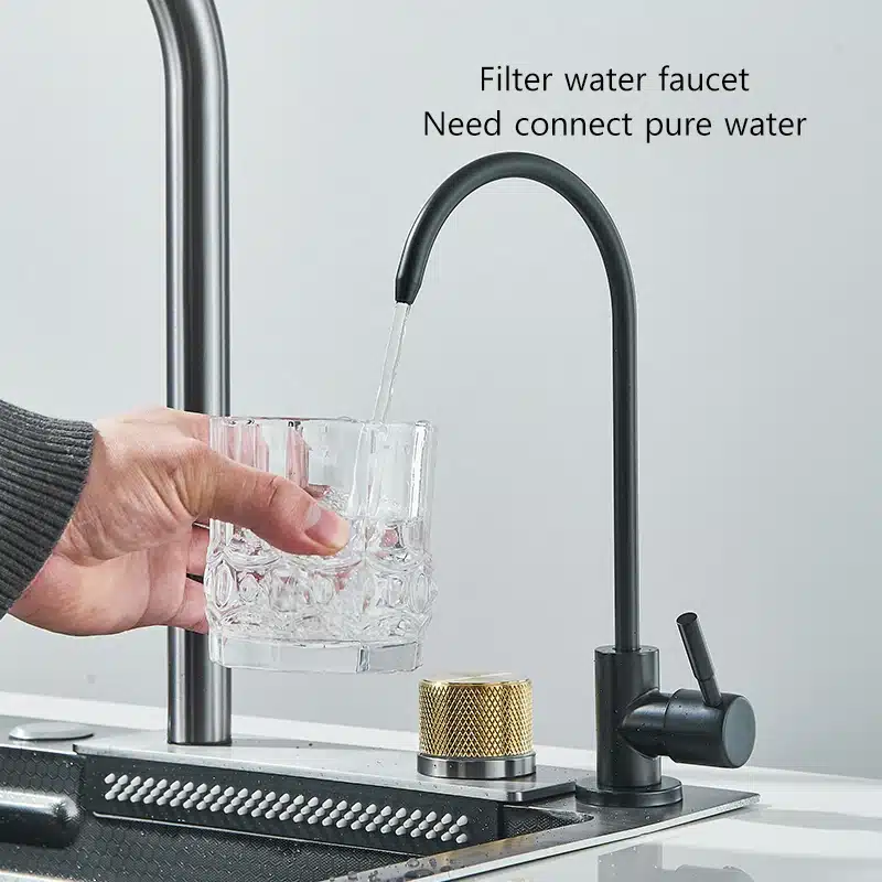 Köögivalamu 304 roostevabast terasest, suur ühekohaline 60x45cm, köögis, mille ääres on must kraan. Kraanist voolab vesi klaasi. Taust on minimalistlik ja kaasaegne.