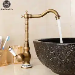 Retro stiilis segisti sinise portselaniga, messingi toonis metallist korpus, paigutatud elegantse musta kausiga kraanikausi kõrvale heledal taustal.