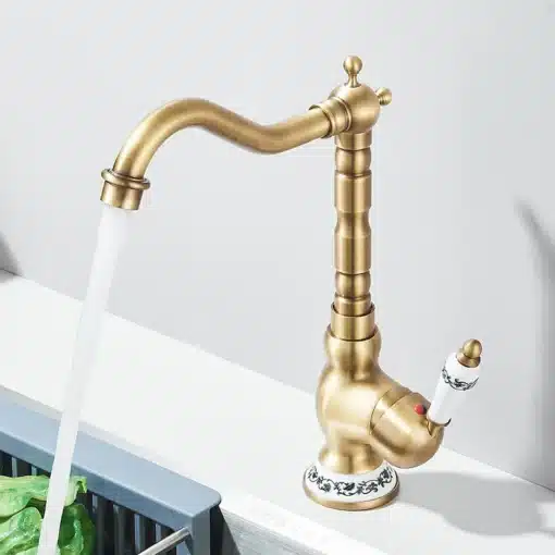 Retro stiilis segisti sinise portselaniga | E-pood Tootemaailm Kuldne retro stiilis segisti sinise portselaniga, voolava veega, paigaldatud köögi valamu kohal, heledal taustal.