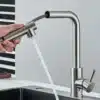 Köögivalamu kraan kõrge rõhuga roostevabast terasest, kuum ja külm vesi | E-pood Tootemaailm Köögivalamu kraan kõrge rõhuga roostevabast terasest, millel on kuuma ja külma vee süsteem, painduv voolik hallil köögitaustal.