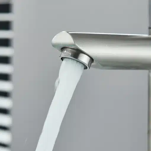 Vannitoa külm veepump kraan ühe käepidemega | E-pood Tootemaailm Stiilne ja kaasaegne vannitoa külm veepump kraan, valmistatud siledast roostevabast terasest, millelt voolab selge vesi hallika tausta ees.