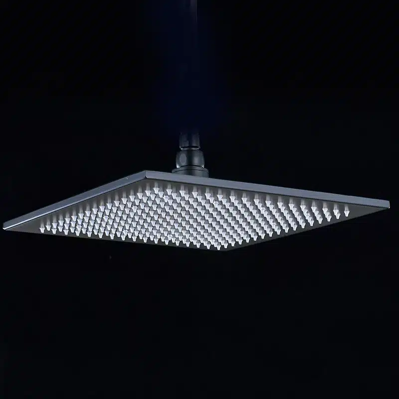 Messingist ruudukujuline vihmadušš, millel on sisse ehitatud LED-valgustus, nähtav pimedal taustal, tuues esile duši kaasaegse ja elegantse disaini.