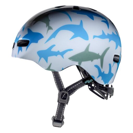 Jalgrattakiiver Nutcase Shark Gloss MIPS 48-52cm | E-pood Tootemaailm Jalgrattakiiver Nutcase Shark Gloss MIPS 48-52cm, millel on stiilne valge pind kaunistatud siniste ja hallide haide kujutistega ning reguleeritavad mustad rihmad. Taust on valge, tootefookus on selge ja esile tõstetud.