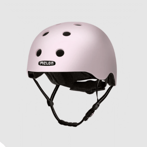 Kiiver Melon Tokyo linnasõitudeks | E-pood Tootemaailm Roosa kiiver MELON Tokyo (M/L) koos musta rihmaga, minimalistliku disainiga sileda pinnaga ja ventilatsiooniavadega hallil taustal.