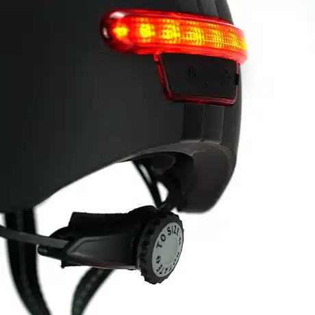 Kiiver MELON E-Series, Black Ice (XL) musta värvi, LED-tagatuled helendavad punaselt, reguleeritava rihmaga, linnataust.
