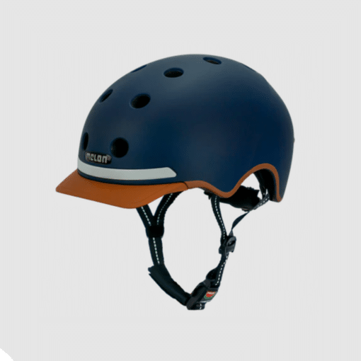 Kiiver Melon E-Series linnasõiduks XL | E-pood Tootemaailm Tumesinise värvusega Kiiver MELON E-Series, Heaven & Earth (XL) koos pruunide detailide ja reguleeritava rihmaga, millel on ventilatsiooniavad puhta halli tausta ees.