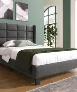 Elegantne üheinimesevoodi pehme peatsiga, viimistletud halli linakangaga mõõtmetega 90x200 cm. Taustal on rohelised seinad ja suured aknad, luues hubase magamistoa meeleolu.
