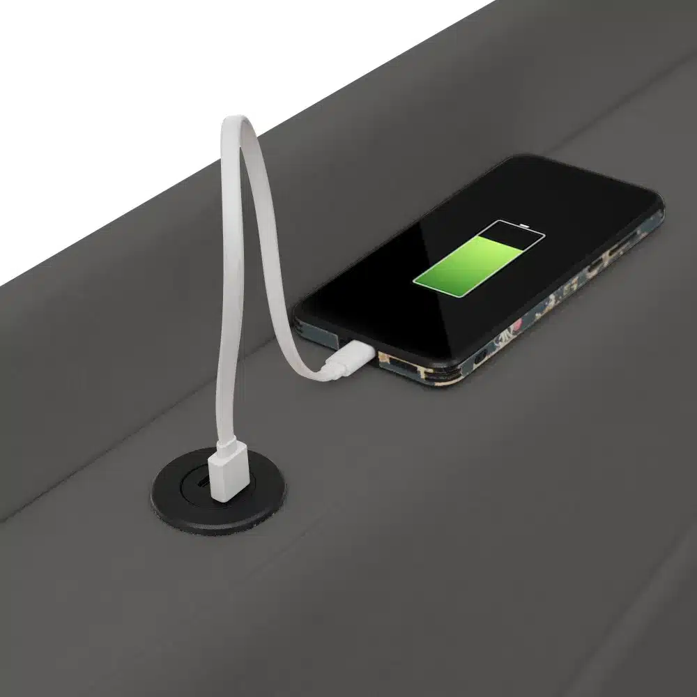 Must Üheinimese voodi koos sisseehitatud USB Type-C laadijaga, millele on ühendatud mobiiltelefon laadimiseks.