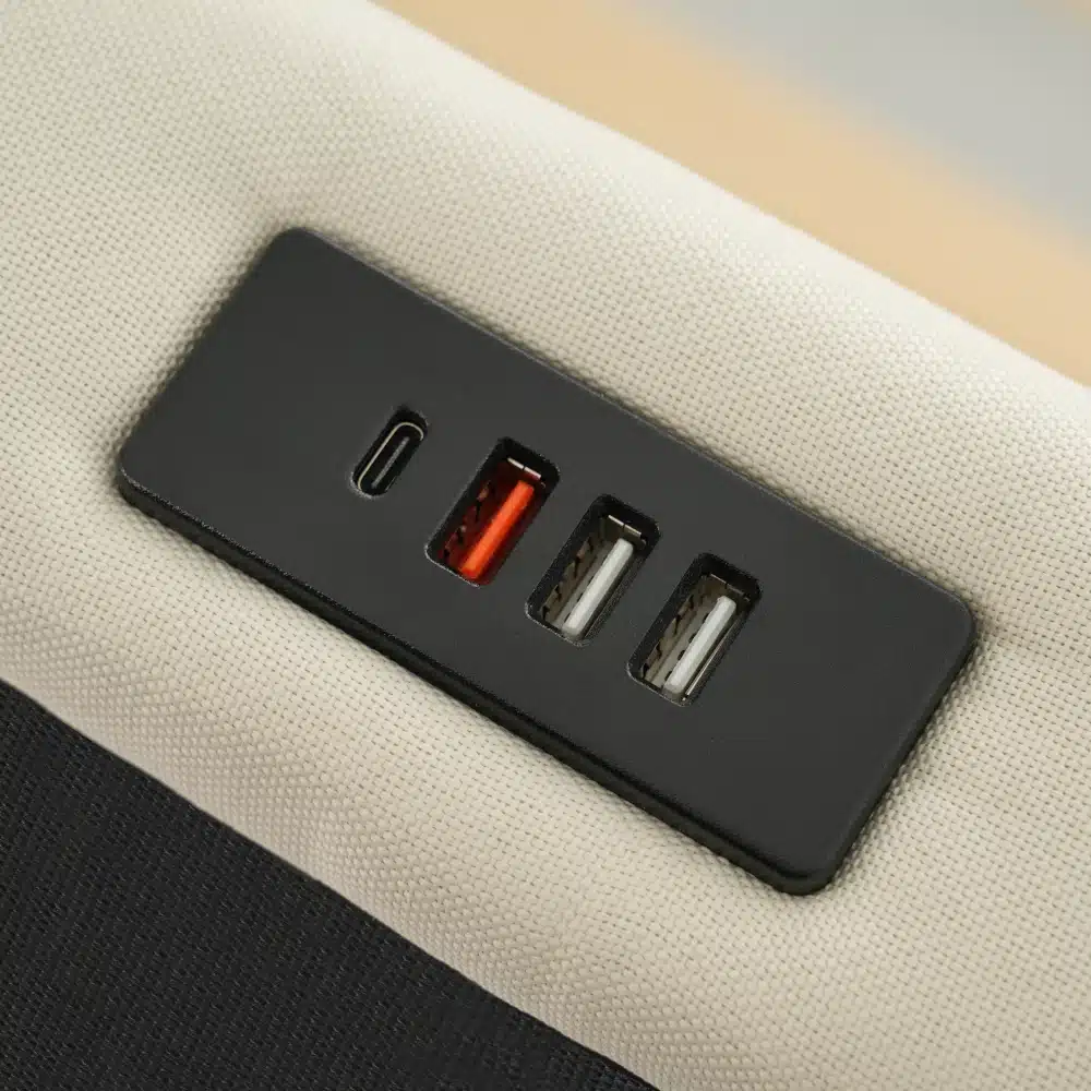 Polsterdatud voodi panipaiga ja LED valgustusega USB-pordid voodipeatsil, mustal taustal, millele on kinnitatud voodipeatsi kangas.