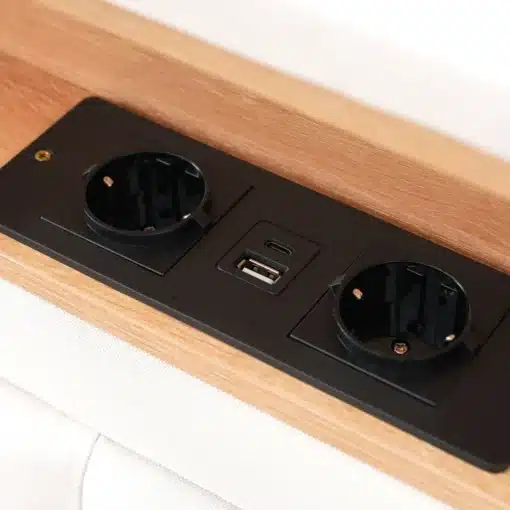 Stiilne voodi USB-C laadijaga ja panipaigaga 160x200 tihedas puidust raamistikus, millele on integreeritud must laadimispaneel, sisaldades USB-C porti ja kahte pistikupesa mugavaks seadmete laadimiseks.