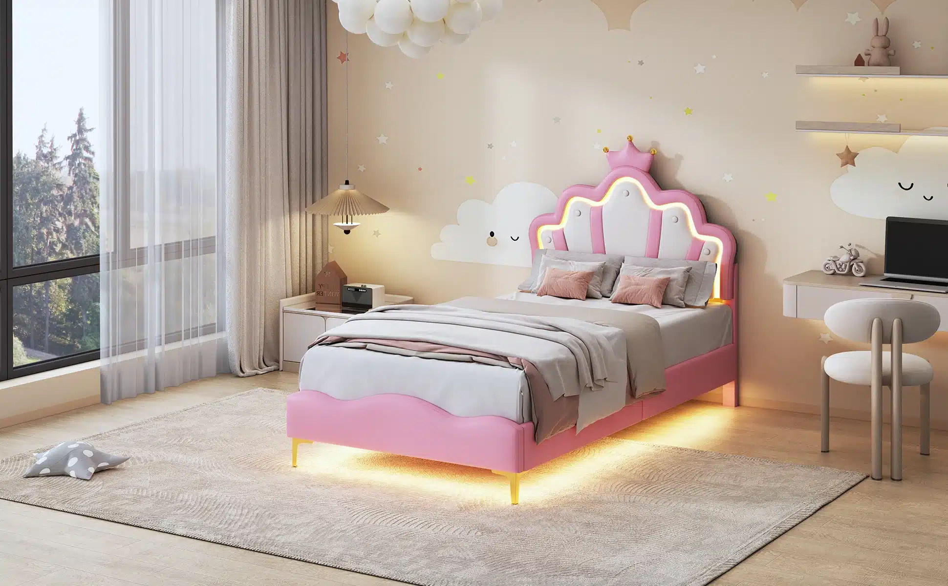 Tüdrukute voodi LED valgustusega roosa 90x200 cm, asub valgusküllases lastetoas. Voodi on roosa tooniga, millel on krooniga kaunistatud peats ja sisseehitatud LED valgustid, mis loovad mugava ja rahuliku magamiskeskkonna. Voodi on paigutatud mugavale vaibale, akna juures suurte kardinatega, mis lasevad sisse loomulikku valgust. Taustal on seinamaal, mis kujutab unistavalt naeratavaid pilvi.
