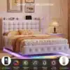 Stiilne polsterdatud voodi, millel on LED valgustus ja USB-pordid 140x200 suuruses, valget värvi modernse sisustusega magamistoas koos beežide voodipesudega.