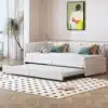 Diivanvoodi ratastel sametist, hall 90x200 cm | E-pood Tootemaailm Stiilne diivanvoodi ratastel, kaetud halli sametkangaga, mõõtudega 90x200 cm. Pilt on tehtud heledas toas, diivanil on dekoratiivpadjad ning taustal on näha disainitud seinakaunistus ja aknaga hele sein.
