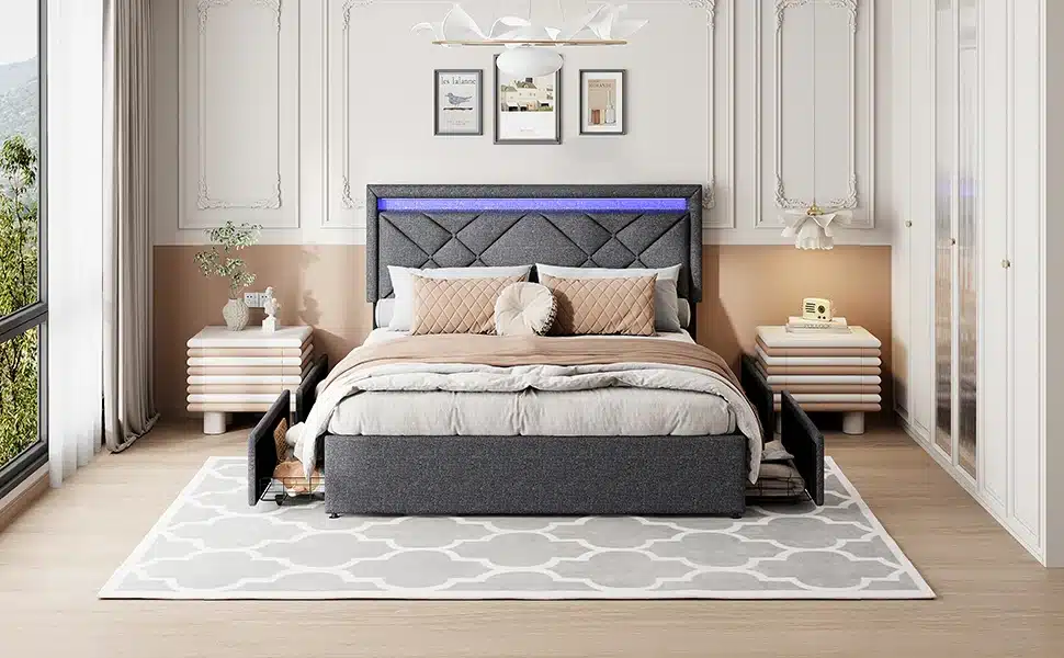 Lai voodi pesukastidega ja LED-valgustusega, tumehall, asub elegantselt kujundatud magamistoas helehalli vaiba peal. Voodi disaini täiendavad peatsil olevad LED-tuled ja külgedel asuvad sahtlid pakuvad praktilist hoiustamislahendust. Taustal on hele seinapaneelid ja minimalistlik mööbel.