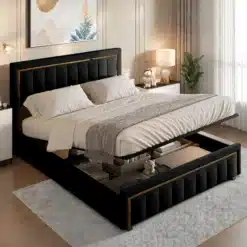 Elegantne polsterdatud voodiraam 140x200 cm, tehtud mustast velvetist koos panipaigaga. Voodi asetseb stiilses ja valgustatud magamistoas, mille taustaks on kaasaegsed kunstiteosed ja õhulised kardinad, luues kutsuva ja mugava atmosfääri.