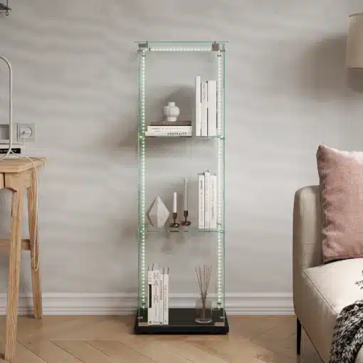 Klaasist vitriinkapp LED-valgustusega, 3 riiuliga | E-pood Tootemaailm Elutoas seisab klaasist vitriinkapp, mille külgedel on helendavad LED-tuled. Kapis on kolm klaasriiulit, mis kannavad elegantseid dekoratiivesemeid ja raamatuid. Kapp asub heledal puitpõrandal, taustal hele seina taust ja diivaninurk.