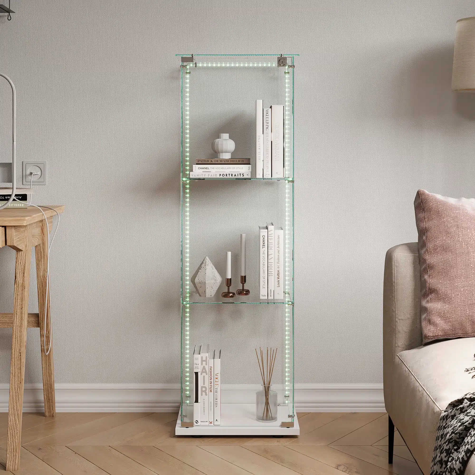 Stiilne klaasist vitriinkapp, millel on LED-valgustusega esile tõstetud kolm riiulit, paigutatud elegantselt minimalistlikus elutoas. Kapp sisaldab valgeid raamatuid ja dekoratiivküünlaid, taustaks hele sein ja puidust põrand.