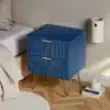 Öökapp kahe sahtliga ja metalljalgadel, tumesinine, asetseb heledal puitpõrandal voodi kõrval, minimalistlikus magamistoas.