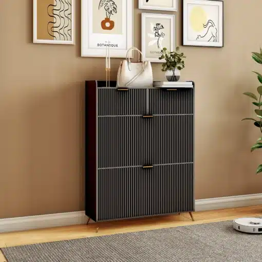Must kingakapp kahe sahtli ja nelja sektsiooniga, mõõtmetega 80x24x110 cm. Kapp on paigutatud stiilsesse elutuppa, ümbritsetud dekoratiivsete piltide ja toataimedega. Kapil olevad kuldsed käepidemed ja peene tekstuuriga pinnaviimistlus lisavad elegantsi.