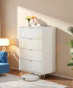 Valge, modernne kummut nelja sahtliga, mõõdud 91x34x60 cm, asetseb elegantses elutoas, millel on sinine diivan ja rohelised taimed, kuldsed käepidemed lisavad luksuslikkust.