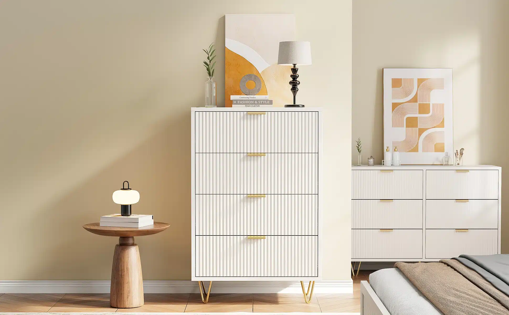 Valge, modernne kummut nelja sahtliga, mõõtudega 91x34x60 cm, asub minimalistlikus toas, taustal heledad seinad ja dekoratiivpildid. Kvaliteetsest materjalist kapi peal on elegantne lauavalgusti ja dekoratiivne raamitud pilt, mis rõhutavad mööbli stiilset disaini.