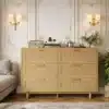 Kummut rotangist 6 sahtliga, millel on puidust jalad ja boho stiilis disain, seisab klassikalises luksuslikus elutoas. Kummuti peal on vintage raadio, dekoratiivne vaas lilledega ja paar aktsentdetaili. Taustal on kreemikad seinad koos elegantsete kuldsete detailidega.