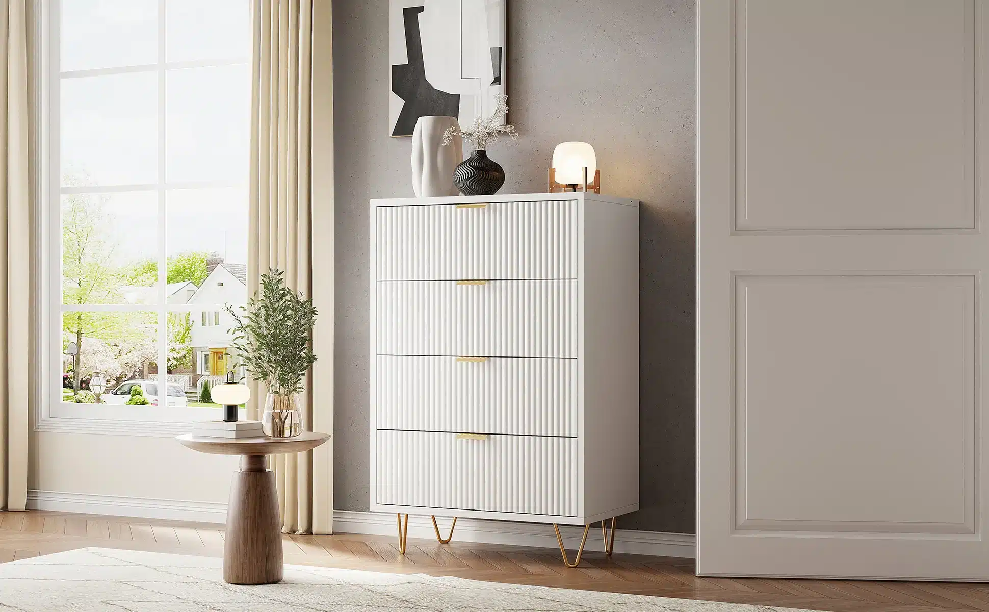Valge, modernne kummut nelja sahtliga seiseb elegantselt päikeselises elutoas; 91x34x60 cm suurused. Kuldse aktsendiga sahtlinupud ja moodne jalgade disain annavad rafineeritud ilme. Taustal suur aken ning avar tuba.