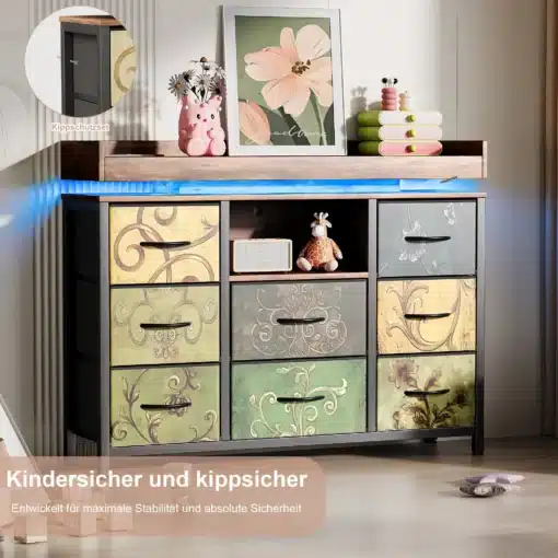 Kummut 8 sahtliga LED-valgustuse ja USB-pesadega, ees erinevates pastelsetes toonides kaunite mustritega sahtlid, mille peal on dekoratiivsed esemed, ning taustal neutraalsed seinad.