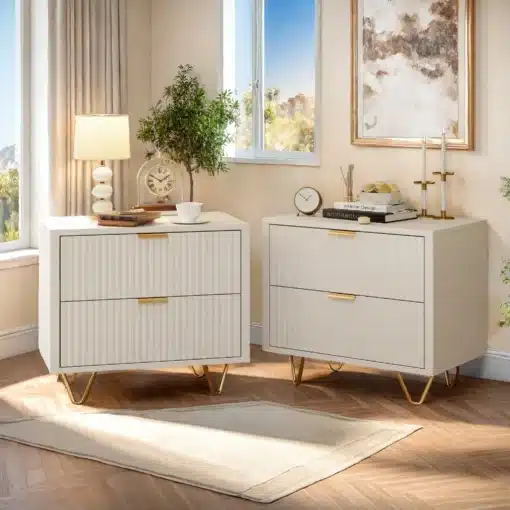 Kahe valge öökapi komplekt, igaühel kaks sahtlit ja kuldsed metalljalad, paiknevad elegantse aknaga valgustatud ruumis, millel on puidust põrand ja heledad kardinad.
